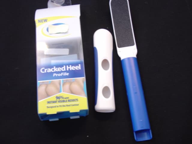 HEEL FILE. OF PLASTIC WITH AN ABRASIVE PAD OF CARBORUNDUM. WITH A 2 PIECE EXTENDABLE HANDLE AND RUBBER GRIP. THE FILE IS SPECIFICALLY CURVED TO REACH THE CONTOURS OF THE HEEL. PACKAGED IN A PLASTIC PRESENTATION BOX.