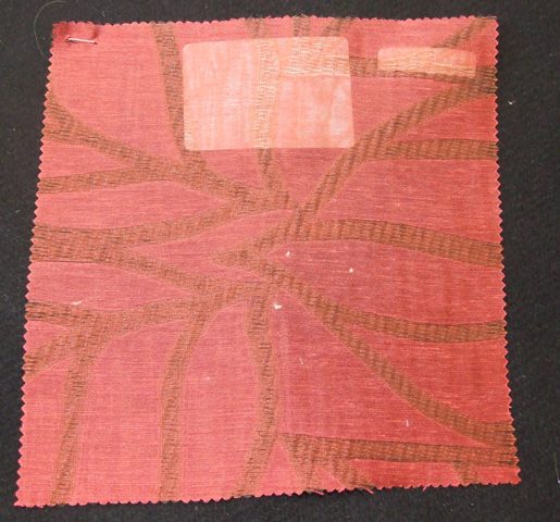 A WOVEN FABRIC MADE OF 100 PER CENT POLYESTER OF A WIDTH 315CMS. MADE OF YARNS OF DIFFERENT COLOURS. NOT PRINTED JACQUARD WOVEN. 85 GRAMS PER METRE. NON-TEXTURED. COLOUR IS DARK RED.