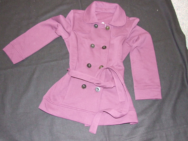 A KNITTED JACKET FOR WOMEN. DESIGNED TO COVER THE UPPER PART OF THE BODY FROM THE SHOULDERS TO THE WAIST. WITH ROUND NECK, WITH COLLAR. WITH COMPLETE FRONT OPENING FASTENED WITH BUTTONS RIGHT OVER LEFT. WITH ATTACHED BELT. WITH POCKETS. THE GARMENT IS MADE FROM 87 PER CENT COTTON AND 13 PER CENT POLYESTER.