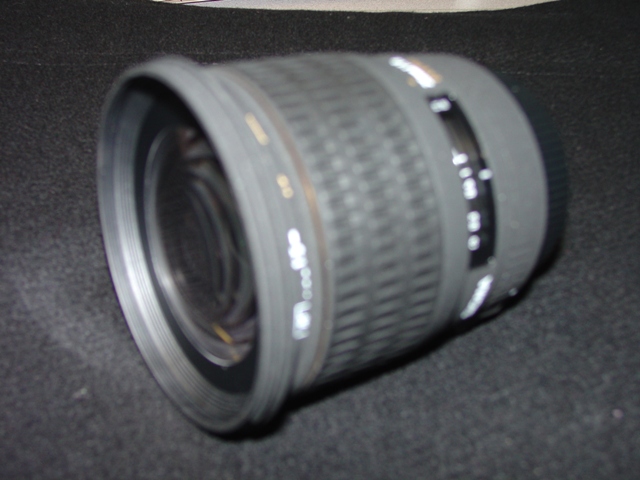 AN OBJECTIVE LENS FOR A PHOTOGRAPHIC CAMERA. OF GLASS, METAL AND PLASTIC. WITH A  FIXED FOCAL LENGTH OF 28MM AND A FRONT DIAMETER OF 77MM. WITH REMOVABLE PLASTIC LENS CAPS. LENS LENGTH 82.5 MM. WEIGHT 500G.