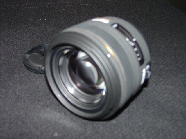 AN OBJECTIVE LENS FOR A PHOTOGRAPHIC CAMERA. OF GLASS, METAL AND PLASTIC. WITH A  FIXED FOCAL LENGTH OF 30MM AND A FRONT DIAMETER OF 62MM. WITH REMOVABLE PLASTIC LENS CAPS. LENS LENGTH 59 MM. WEIGHT 430G.