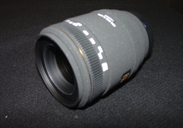 AN OBJECTIVE LENS FOR A PHOTOGRAPHIC CAMERA. OF GLASS, METAL AND PLASTIC. WITH A  FIXED FOCAL LENGTH OF 50MM AND A FRONT DIAMETER OF 55MM AND OVERALL DIAMETER OF 71.4MM. WITH REMOVABLE PLASTIC LENS CAPS. LENS LENGTH 66.5 MM. WEIGHT 320G.