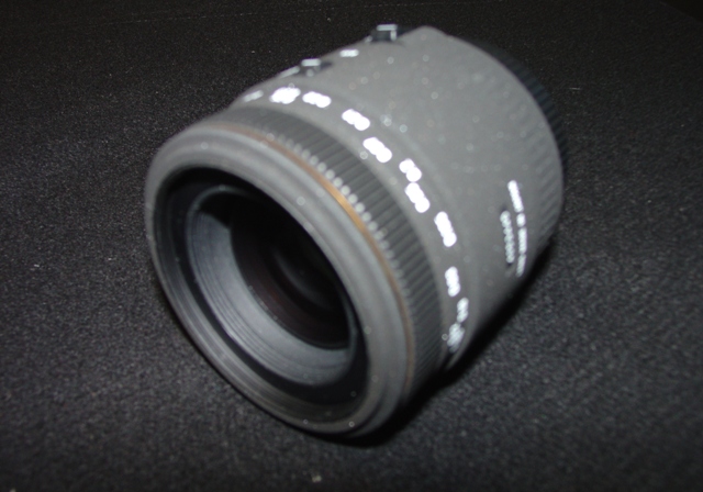 AN OBJECTIVE LENS FOR A PHOTOGRAPHIC CAMERA. OF GLASS, METAL AND PLASTIC. WITH A  FIXED FOCAL LENGTH OF 70MM AND A FRONT DIAMETER OF 62MM AND OVERALL DIAMETER OF 76MM. WITH REMOVABLE PLASTIC LENS CAPS. LENS LENGTH 95 MM. WEIGHT 527G.