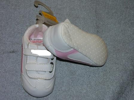 BABIES TRAINER STYLE INDOOR SHOE, FOR UP TO 18 MONTHS. WITH UPPERS OF PLASTIC.  WITH VELCRO STRAP FASTENING. WITH EMBROIDERED LOGO ON STRAPS. OUTER SOLES OF TEXTILE MATERIAL WITH RAISED PLASTIC DOTS. TEXTILE IS PREDOMINANT MATERIAL IN CONTACT WITH THE GROUND. WHITE IN COLOUR WITH PINK TRIM.  PRESENTED ON A LITTLE PLASTIC HANGER WITH CARD LABEL