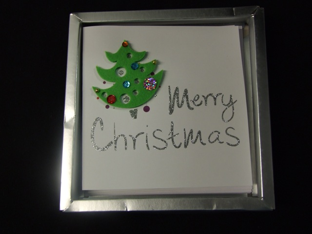 SET OF 5 PRINTED CHRISTMAS CARDS WITH PRINTED  PICTURE ON FRONT OF CARD. WITH APPLIED TEXTILE CHRISTMAS TREE MOTIF DECORATED WITH SEQUINS. WITH GLITTER GREETING ON FRONT OF CARD AND PRINTED GREETING INSIDE.WITH ENVELOPES. PACKAGED FOR RETAIL SALE IN A PAPERBOARD TRAY  WITH PLASTIC COVER.