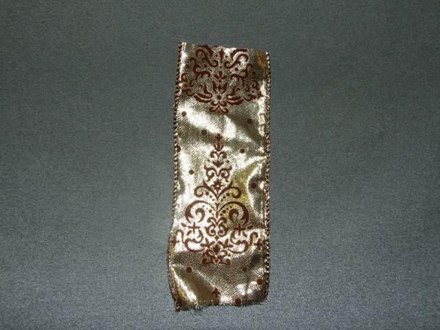 A NARROW WOVEN GOLD FABRIC OF MAN MADE FIBRES, POLYESTER. MEASURING 6CMS IN WIDTH. HEMMED AT EDGES AND REINFORCED WITH METAL WIRE. DECORATED WITH A BROWN FLOCKED DESIGN. PACKAGED FOR RETAIL SALE ON REELS AND IS PACKAGED IN A POLYBAG.