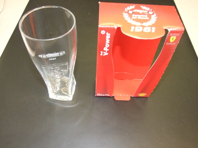 A DRINKING GLASS MADE OF SODA LIME GLASS. WITH A PRANCING HORSE LOGO DECORATION AND A FERRARI RACING CAR ETCHED ON THE GLASS. PACKAGED IN A CARD PRINTED SLEEVE.