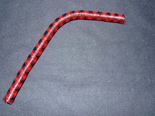 TUBULAR BRAID. OF NYLON AND METAL. WITH A NON COMPACT STRUCTURE. USED FOR DECORATIVE PURPOSES. MADE ON A BRAIDING MACHINE.