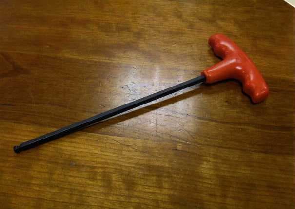 A HAND TOOL WITH A HEXAGONAL SHAFT WITH A BALL END AND A PLASTIC T HANDLE AT THE OTHER END.