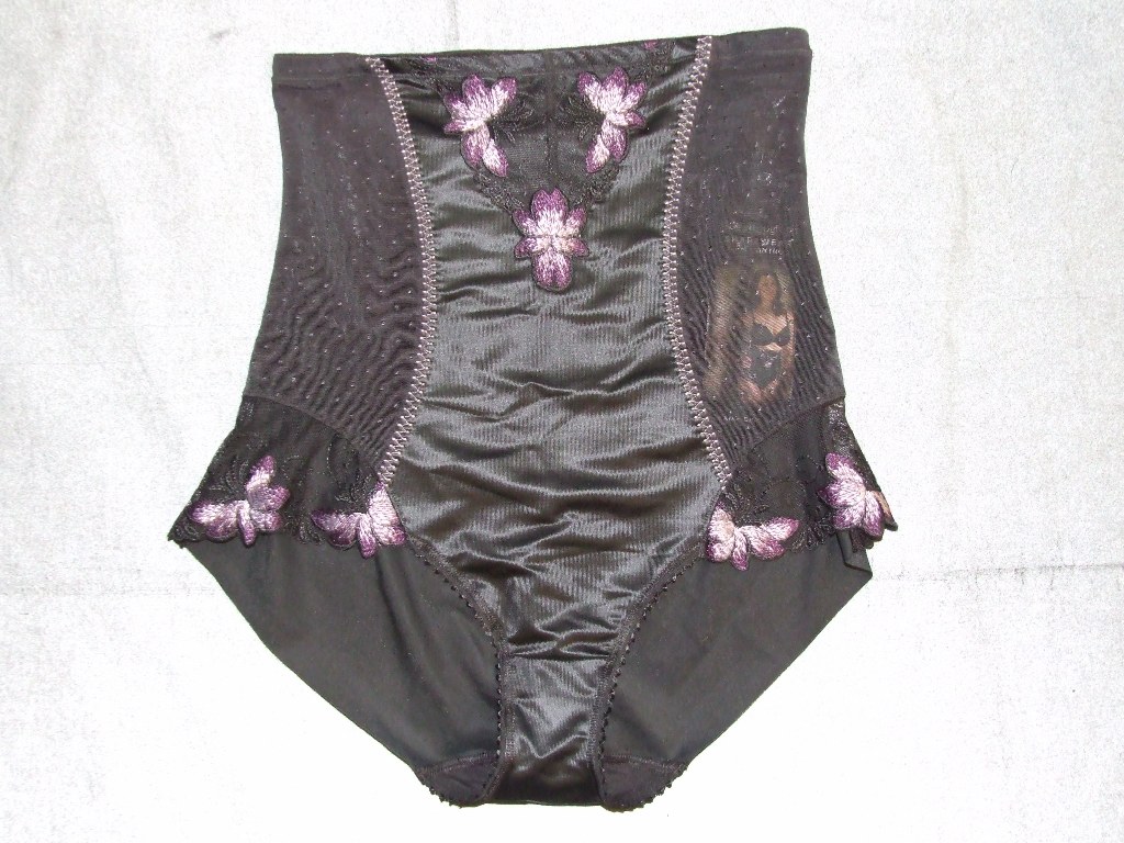 KNITTED LADIES PANTY-GIRDLE IN BLACK WITH LILAC TRIMMINGS. MADE OF 59% POLYAMIDE, 34% ELASTANE AND 7% POLYESTER. DESIGNED TO HUG THE WAIST AND THE HIPS. WITH SIDE PANELS OVER 8CM IN LENGTH COVERING THE BODY FROM JUST UNDER THE BUST DOWN TO THE TOP OF THE LEG LINE. WITH VERTICAL ELASTICITY AND RESTRICTED HORIZONTAL ELASTICITY. GARMENT CONSISTS OF AT LEAST 15% ELASTOMER YARN CONTENT.