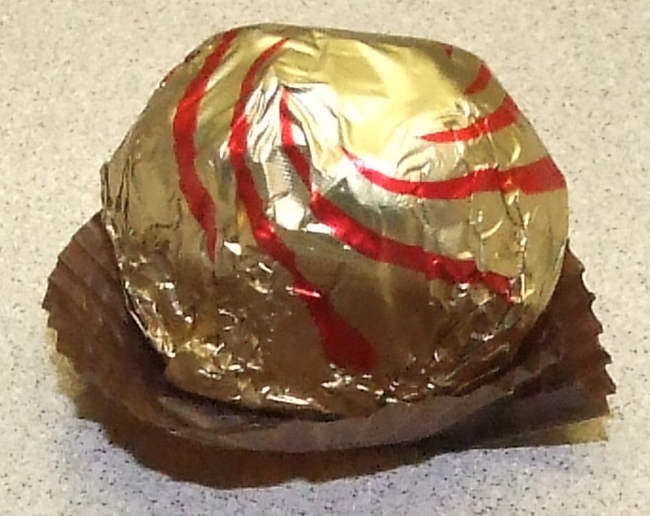 CHOCOLATE COVERED NUT PRALINE WITH HAZELNUT FILLING. INGREDIENTS INCLUDE: GLUTEN, MILK PRODUCTS, HAZELNUT, SOY AND COCOA