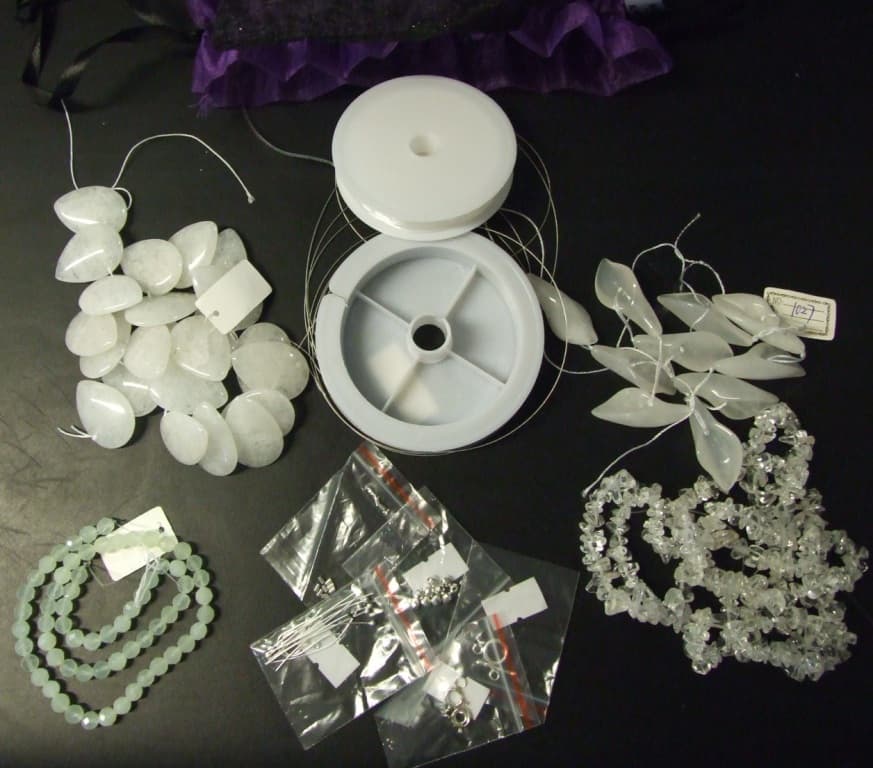 A JEWELLERY KIT COMPRISING OF JADE FLAT DROP BEADS, JADE CATTLE EAR BEADS, WHITE QUARTZ CHIPS,  FACETED BEADS, CRIMPS, CLASPS, HEADPINS AND TWO DIFFERENT TYPES OF WIRE, CONTAINED IN TWO GIFT BAGS.