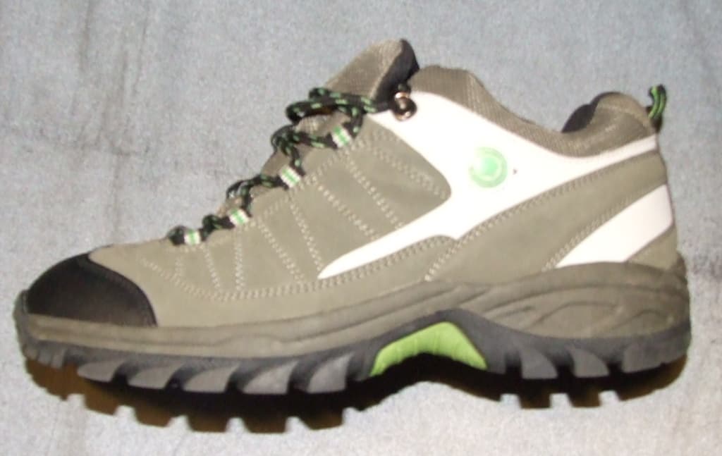 UNISEX TRAINING STYLE WALKING SHOE. NOT COVERING THE ANKLE. WITH UPPERS OF PLASTIC AND TEXTILE WHERE THE PLASTIC PREDOMINATES. OUTER SOLES OF SYNTHETIC MATERIAL WITH A THICK TREAD FOR GRIP. LACE UP FASTENING WITH LOOPS.   WITH AN INSOLE LENGTH OF MORE THAN 24CMS. WITH LOGO ON TONGUE AND SIDE OF THE SHOE. IVY GREEN IN COLOUR. LOOP AT THE BACK BLACK IN COLOUR WITH BRIGHT GREEN STRIPE DOWN THE MIDDLE.
