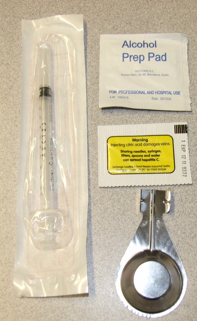 A KIT DESIGNED TO BE USED BY INJECTING DRUG USERS. CONSISTING OF A PLASTIC FILTER SYRINGE WITH A NEEDLE, A STAINLESS STEEL RECEPTACLE, AN ALCOHOL WIPE AND A SMALL SACHET OF CITRIC ACID. THE KIT CONTAINS ENOUGH CLEAN WORKS FOR A SINGLE INJECTION. WITH A SCRATCH OFF PANEL ON THE SYRINGE TO CREATE A UNIQUE PIN NUMBER TO HELP REDUCE THE RISK OF ACCIDENTAL SHARING. ALL ITEMS PACKED TOGETHER IN STERILE PLASTIC PACKAGING PRINTED WITH A HARM REDUCTION MESSAGE.