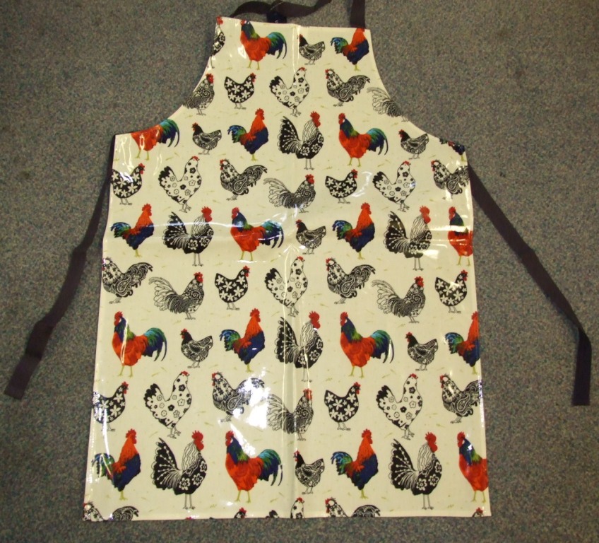 A WOVEN APRON FOR UNISEX. COVERING THE FRONT OF THE BODY.  WITH A STRAP FOR WEARING AROUND THE NECK, AND TWO STRAPS EXTENDING FROM THE SIDES FOR FASTENING AROUND THE BACK. WITH A NON- VISIBLE PVC COATING ON THE OUTER SURFACE OF THE FABRIC. WITH PRINTED DESIGN.  OF 100% COTTON.