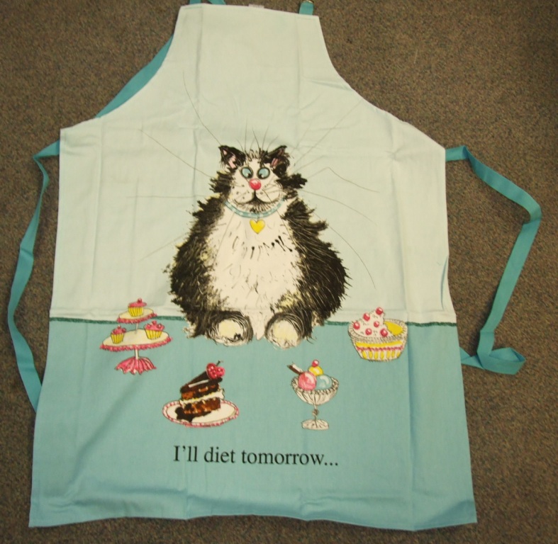 A WOVEN APRON FOR UNISEX. COVERING THE FRONT OF THE BODY.  WITH A STRAP AND BUCKLE FOR WEARING AROUND THE NECK, AND TWO STRAPS EXTENDING FROM THE SIDES FOR FASTENING AROUND THE BACK. WITH PRINTED CAT DESIGN.  OF 100% COTTON.