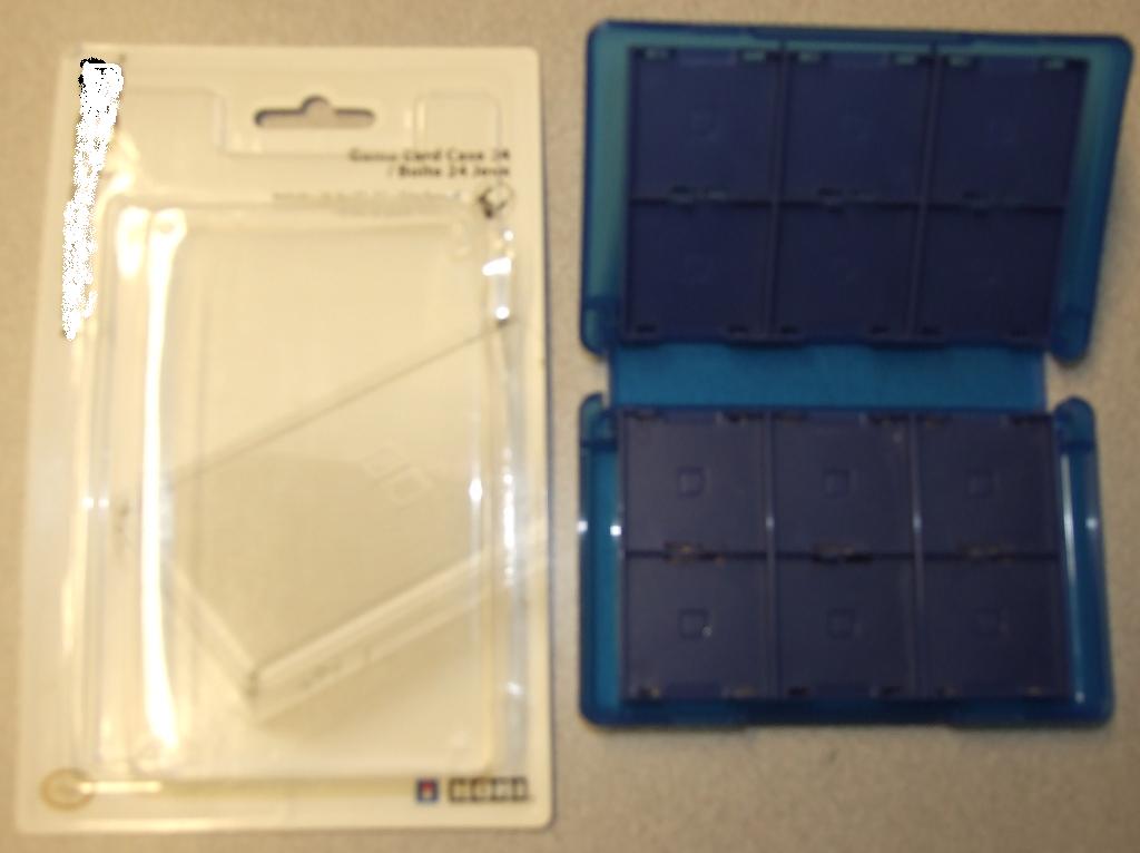 A LIGHTWEIGHT PROTECTIVE CASE OF MOULDED PLASTIC.  DESIGNED TO HOLD 24 SD GAME CARDS.  FEATURES TWO RIGID PLASTIC MOVABLE INSERTS EACH HOLDING 6 CARDS ON EITHER SIDE.  PUT UP FOR RETAIL SALE BLISTER PACKED.  DIMMENSIONS W12.5 X H8 X D2 CM.