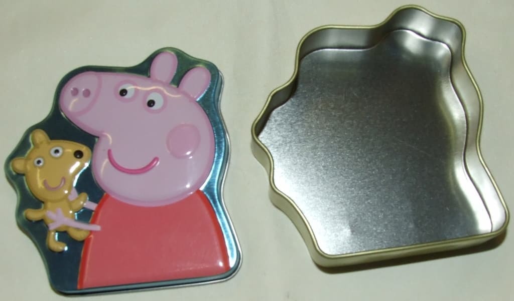 EMPTY SWEET TIN WITH A LID MADE FROM TIN PLATED STEEL WITH A WALL THICKNESS OF 0.22M. THE TIN DEPICTS A CARTOON PIG.