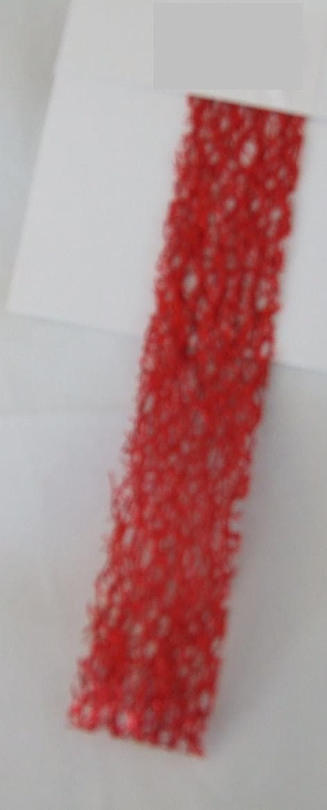 NARROW KNITTED FABRIC. A RED DECORATIVE TRIMMING WITH SHINY UPPER SURFACE THAT DOES NOT OBLITERATE THE WEAVE OF THE FABRIC. 23MM WIDE. 100% POLYESTER. PRESENTED AS PART OF A MIXED SET OF KNITTED AND WOVEN TRIMMINGS AND RIBBONS. ALL CLASSIFIED SEPARATELY.
