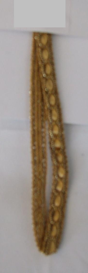 NARROW KNITTED FABRIC. A GOLD COLOURED DECORATIVE TRIMMING CONSTRUCTED FROM KNITTED, GIMPED AND METALLIC YARNS. 9MM WIDE. 17% POLYESTER. 20% NYLON. 63% METALLISED YARN. PRESENTED AS PART OF A MIXED SET OF KNITTED AND WOVEN TRIMMINGS AND RIBBONS. ALL CLASSIFIED SEPARATELY.