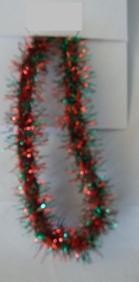 NARROW KNITTED LONG PILE FABRIC. A DECORATIVE TRIMMING CONTRUCTED FROM KNITTED THREADS LOOPED LOOSELY TOGETHER. THE THREADS HAVE A RED AND GREEN METALLIC PILE. APPROX 10MM WIDE. 39.9% POLYESTER. 60.1% METALLISED YARN. PRESENTED AS PART OF A MIXED SET OF KNITTED AND WOVEN TRIMMINGS AND RIBBONS. ALL CLASSIFIED SEPARATELY.