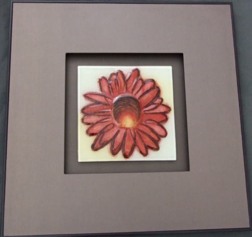 PAINTING ON GLASS EXECUTED ENTIRELY BY HAND. A DECORATIVE HAND PAINTED GLASS PLAQUE. MOUNTED IN A LARGE BROWN PLASTIC FRAME WITH A WOODEN BROWN SURROUND. A FLOWER DESIGN HAND PAINTED ONTO FUSED GLASS. WITH A PRINTED LABEL ON THE BACK DEPICTING INFORMATION ON THE ARTIST. OVERALL DIMENSIONS HEIGHT 60CM X WIDTH 60CM X DEPTH 3CM. PLAQUE DIMENSIONS HEIGHT 24CM X WIDTH 24CM. PRESENTED IN A PRINTED CARDBOARD BOX.