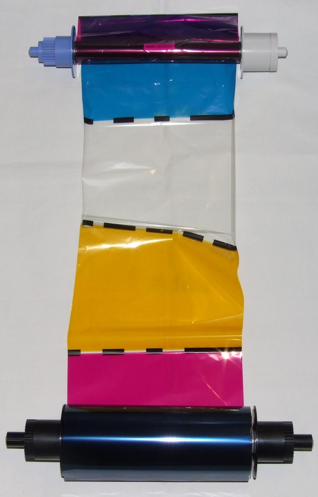 PLASTIC PRINTER RIBBON ON A ROLL. WITH DIFFERENT COLOURED SEGMENTS PROVIDING THE PENETRATION OF DYES BY HEAT. FOR PHOTOGRAPHY USE ONLY. MOUNTED ON 2 SPOOLS. WIDTH OF RIBBON 16 CM.