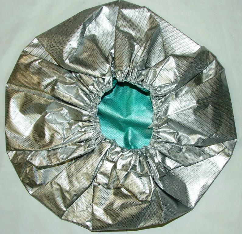 DISPOSABLE SINGLE USE SURGICAL CAP. OF 97% NON WOVEN POLYPROPYLENE LAMINATED WITH 3% ALUMINIUM. IN THE PIECE. ELESTICATED TO HOLD CAP IN PLACE. USED AS A SINGLE USE DISPOSABLE PRODUCT TO REFLECT AND RETAIN PATIENTS BODY HEAT BEFORE, DURING AND AFTER SURGERY.