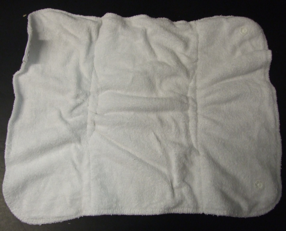 KNITTED EXTRA INSERT FOR A BABY NAPPY OF 70% BAMBOO AND 30% COTTON. CAN BE SHAPED AND HELD IN PLACE WITH STUDS.