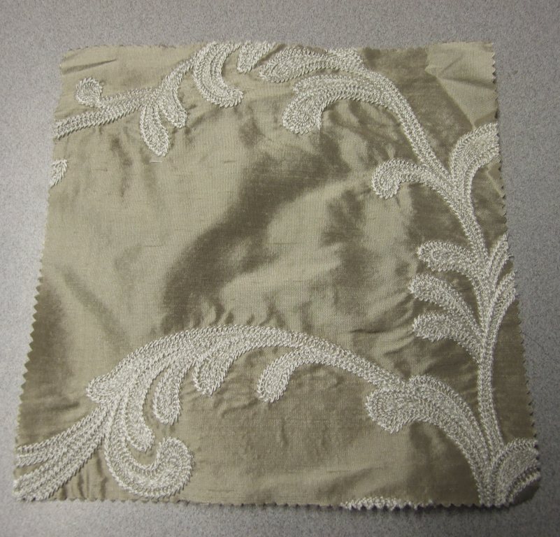 WOVEN EMBROIDERED FABRIC. VISIBLE GROUND FABRIC OF SILK, WITH EMBROIDERED FLORAL PATTERN OF 90% VISCOSE AND 10% POLYESTER. TOTAL FIBRE CONTENT 52% VISCOSE, 42% SILK AND 6% POLYESTER. WEIGHING 209 GM2. WIDTH 132CM. NOT MANUFACTURED ON A HAND LOOM. VALUE EXCEEDS 17.5 EUROS PER KG NET WEIGHT.