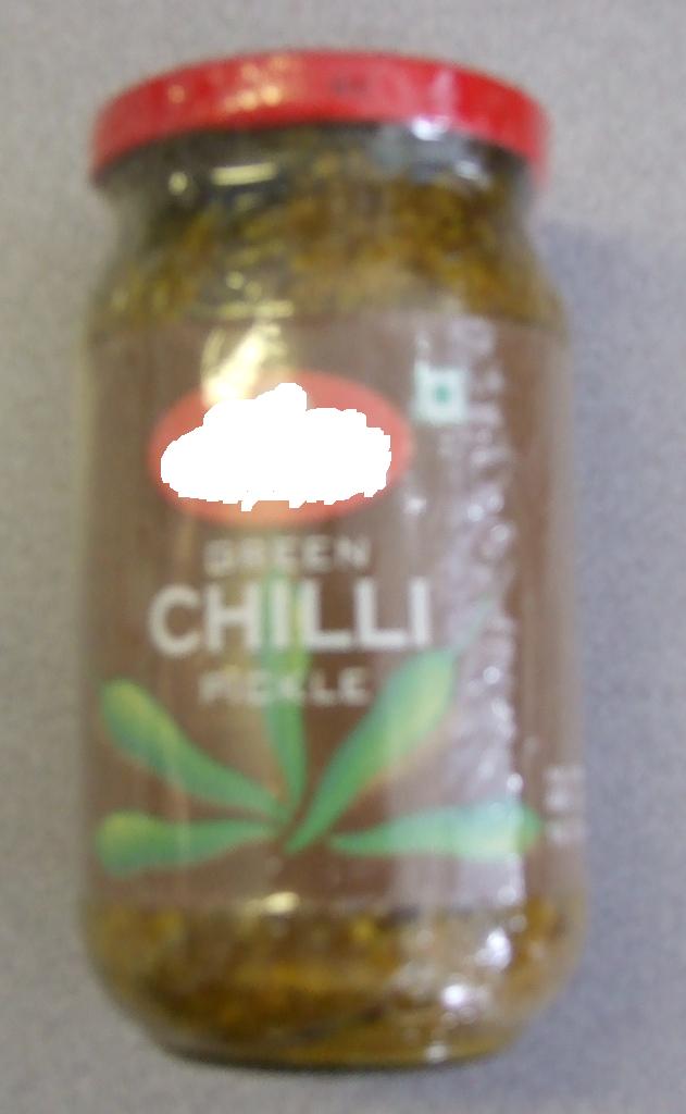 GREEN CHILLI PICKLE. GREEN CHILLI PIECES IN A SPICY SAUCE. INGREDIENTS INCLUDE GREEN CHILLI PIECES 65%, SALT 13%, VEGETABLE OIL 10.38%  FENUGREEK AND ACETIC ACID 1.6%. PACKAGED IN A GLASS JAR.