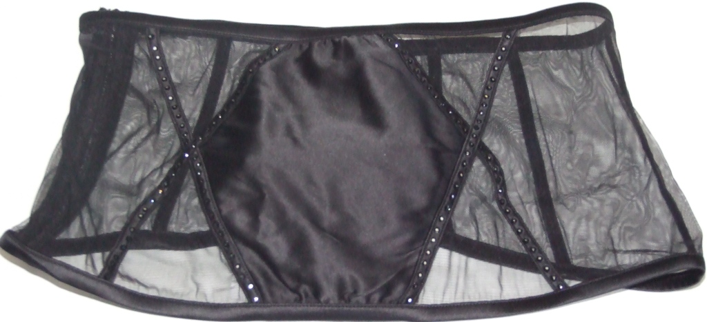 A KNITTED WASPIE DESIGNED TO GO ROUND THE WAIST. WITH WOVEN FRONT PANEL. WITH SMALL BEADED DECORATION TO FRONT AND BACK OF GARMENT. WITH SIDE ZIP FASTENING.