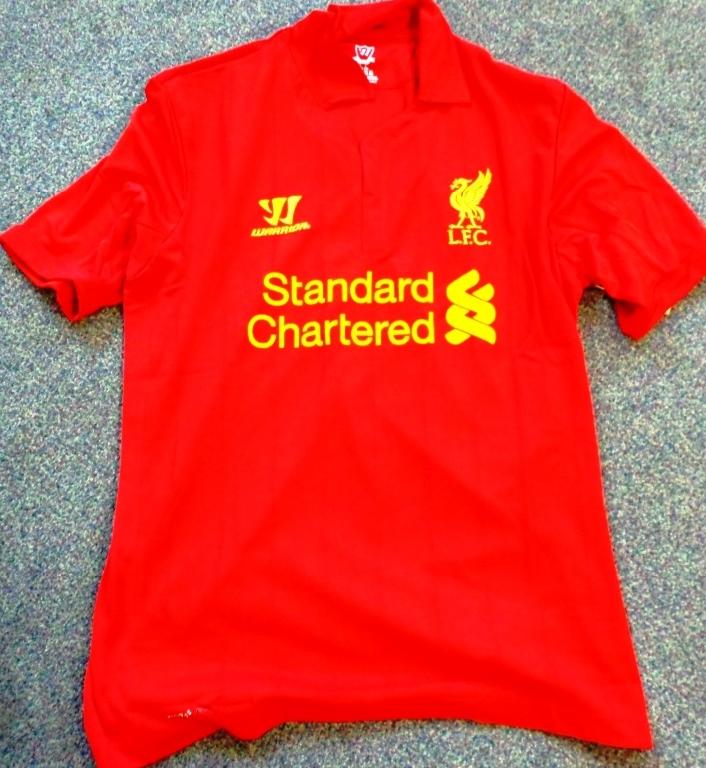A KNITTED FOOTBALL SHIRT FOR MEN. DESIGNED TO COVER THE UPPER PART OF THE BODY FROM THE SHOULDERS TO BELOW THE WAIST. WITH SHORT SLEEVES. WITH ROUND NECK WITH PARTIAL OPENING. WITH LEFT OVER RIGHT FLAP AT OPENING. WITH COLLAR. HEMMED AT SLEEVES AND WAIST. MADE FROM 84% POLYESTER, 16% RECYCLED POLYESTER PLUS 100% POLYESTER PANELS.
