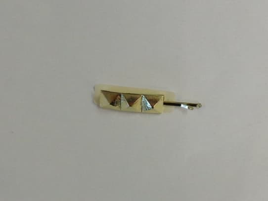 METAL HAIR CLIP. GOLD IN COLOUR WITH THREE DECROTIVE PYRAMIDS.