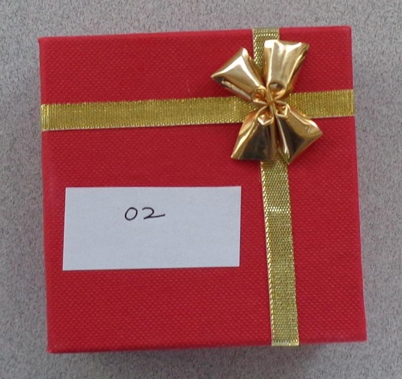 THIS IS A BOX USED TO GIVE AWAY JEWELLERY OR GIFTS FOR PRESENTATION PURPOSES. IT IS RED IN COLOUR AND HAS A GOLD DECORATIVE TIE. IT IS MADE OF CARD. IT IS 8X8CM.