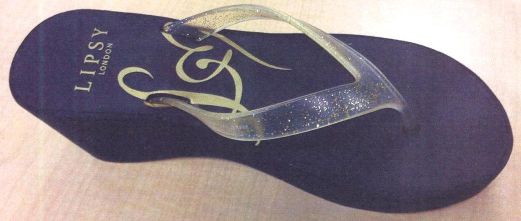 LADIES CASUAL WEDGE FLIP FLOP. WITH UPPERS CONSISTING OF A GLITTERY CLEAR PLASTIC THONG ASSEMBLED TO THE SOLE BY MEANS OF PLUGS. WITH OUTER SOLE OF RUBBER/PLASTIC, BLACK IN COLOUR. WEDGE 6.5CM. INSOLE LENGTH 24CMS. WITH LOGO ON HEEL AND INSOLE.