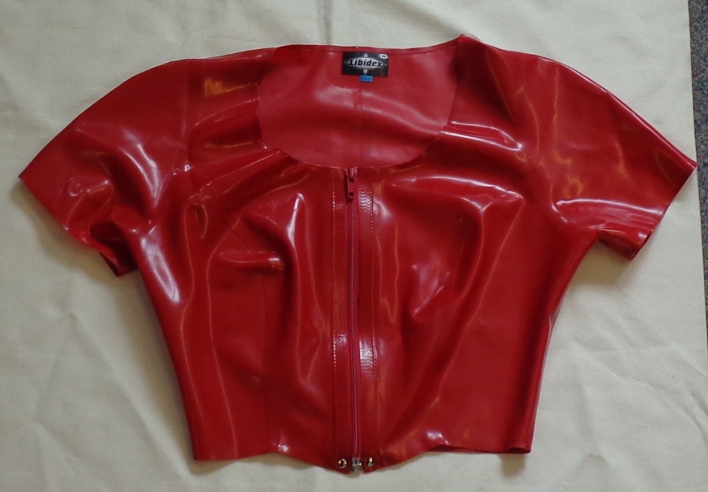 AN UPPER GARMENT FOR WOMEN. MADE OF NATURAL LATEX RUBBER. ROUND NECK. COMPLETE OPENING AT THE FRONT FASTENED BY ZIP.WITH SHORT SLEEVES