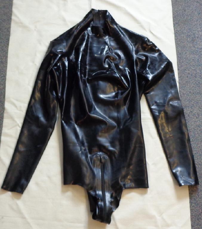 A LEOTARD STYLE GARMENT FOR WOMEN. MADE OF NATURAL LATEX RUBBER. ROUND NECK WITH COLLAR. COMPLETE OPENING AT THE BACK WHICH EXTENDS UNDER THE CROTCH TO THE FRONT, FASTENED BY ZIP. LONG SLEEVES.