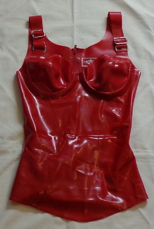 AN UPPER GARMENT FOR WOMEN. MADE OF NATURAL LATEX RUBBER. WITH ADJUSTABLE SHOULDER STRAPS AND UNDERWIRED AT BUST. COMPLETE OPENING AT THE BACK FASTENED BY ZIP.
