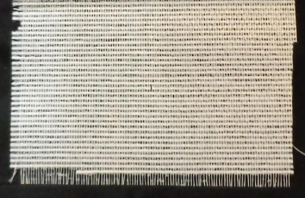 A FIBREGLASS WALL COVERING, MADE FROM PLAIN WEAVE GLASS FIBRES (WHERE ONE WARP YARN GOES OVER ONE WEFT YARN AND UNDER THE NEXT WEFT YARN AND ONE WEFT YARN GOES OVER ONE WARP YARN AND UNDER THE NEXT WARP YARN).  THE LENGTH IS 25 M. WIDTH 100 CM.  THICKNESS 0.27 MM.  THE TEX MEASUREMENT OF THE WARP IS 143 AND OF THE WEFT 417. THE AVERAGE GAP BETWEEN THE WARP YARNS IS 4.19 MM AND BETWEEN THE WEFT 2.76 MM. WEIGHT:  105 G/M2.