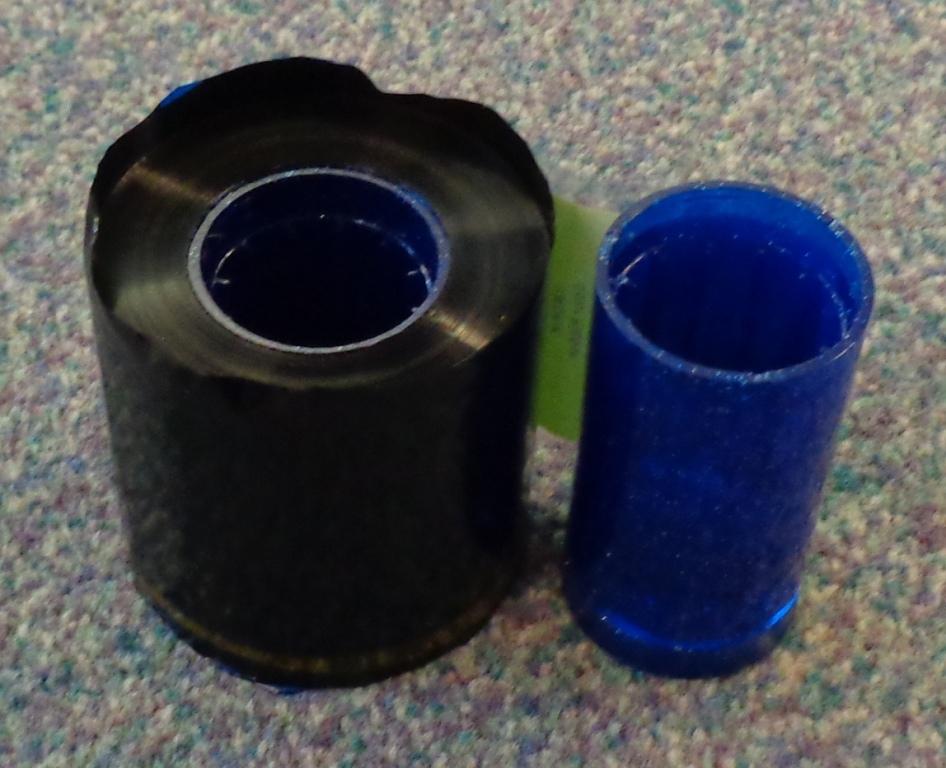 PLASTIC PRINTER RIBBON ON A ROLL. WITH DIFFERENT COLOURED SEGMENTS PROVIDING THE PENETRATION OF DYES BY HEAT. MOUNTED ON 2 SPOOLS WHICH ARE 6CM WIDE.