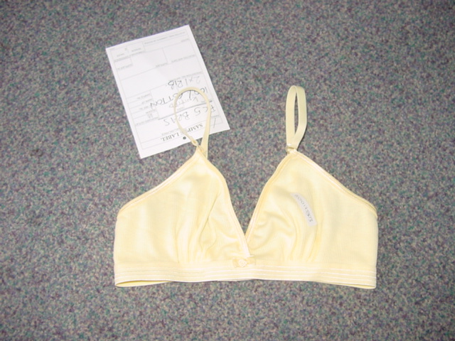 A KNITTED CHILDS BRA. WITHOUT UNDERWIRE. WITH ADJUSTABLE SHOULDER STRAPS. WITH SHAPED CUPS. WITH A HOOK AND EYE FASTENING AT THE BACK. WITH ELASTICATION AT THE BASE. 100 PER CENT COTTON.
