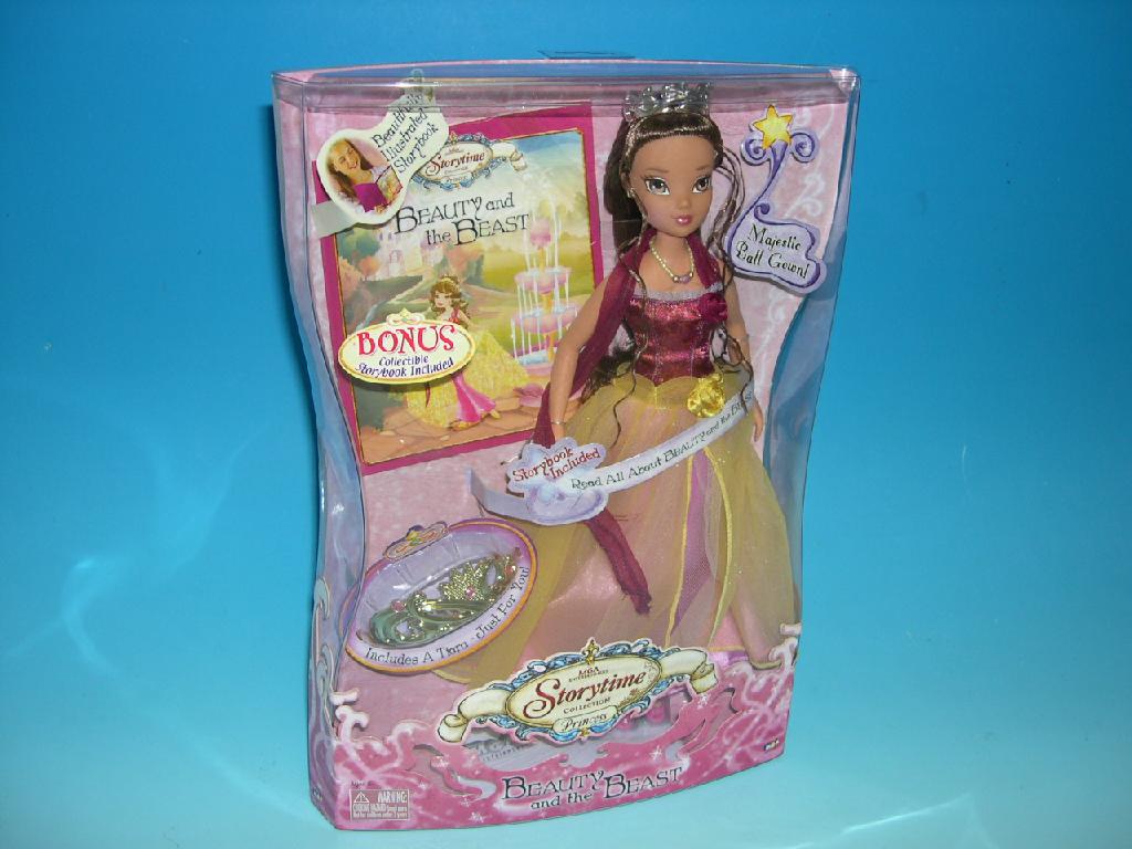 A PLASTIC DRESSED DOLL REPRESENTING A HUMAN - BEAUTY FROM BEAUTY AND THE BEAST. PRESENTED WITH A BOOK OF THE STORY AND A PLASTIC TIARA FOR GIRLS TO WEAR. PACKAGED IN A CLEAR ACETATE BOX.