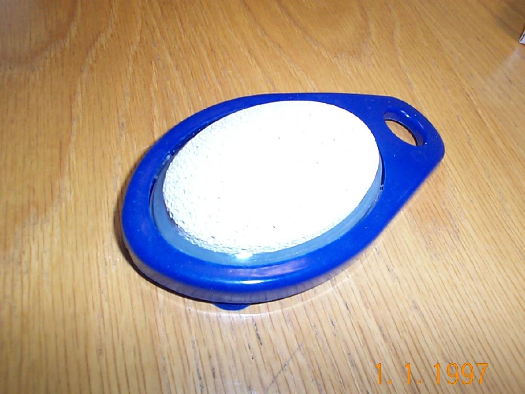 PUMICE STONE ATTACHED TO A PLASTIC HOLDER. THE BACK OF THE HOLDER HAS SUCTION CUPS SO IT CAN BE PLACED IN THE BATH OR SHOWER.