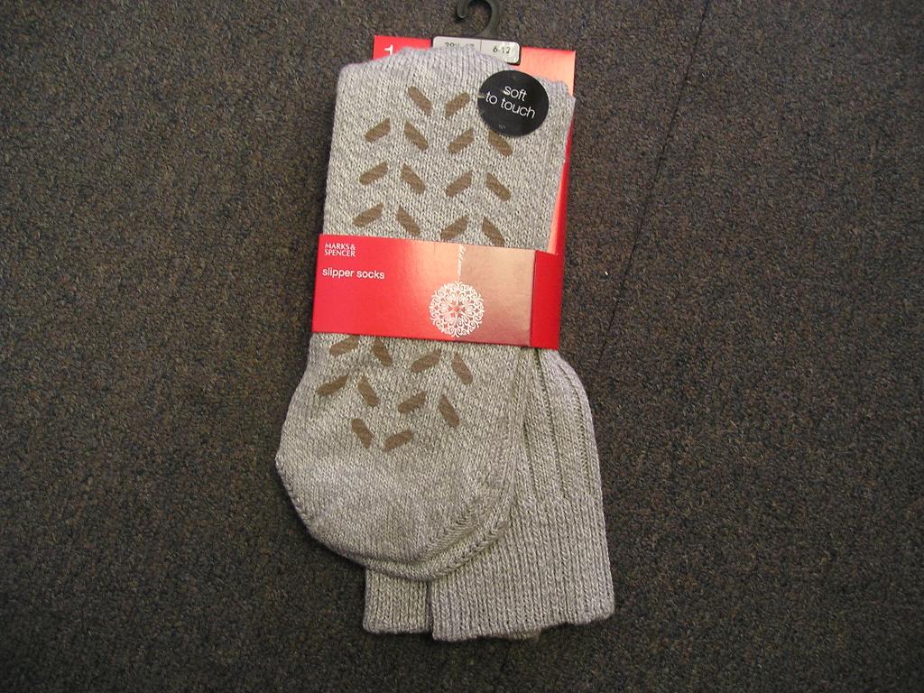 A PAIR OF KNITTED SLIPPER SOCKS. WITH RUBBER DOTS ON SOLE. OF 49 PERCENT WOOL, 32 PERCENT COTTON AND 19 PERCENT POLYAMIDE. PACKAGED ON A CARDBOARD HANGING PACK.