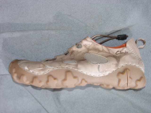MANS SHOE IN THE STYLE OF A TRAINER. NOT COVERING THE ANKLE. UPPERS OF LEATHER AND TEXTILE MATERIAL WHERE THE LEATHER PREDOMINATES.  THE TEXTILE FORMS A COMPLETE LINING AND IS ELASTICATED AROUND THE TOP. ON ITS OWN IT WOULD NOT BE DEEMED TO BE A VIABLE OUTER SURFACE. OUTER SOLES OF RUBBER/PLASTIC. WITH LOGO ON THE HEEL AND SIDE OF THE SHOE. LACE FASTENING. INSOLE LENGTH EXCEEDING 24 CMS. SPECIAL TECHNOLOGY FEATURES IN THE FORM OF AN EVA MIDSOLE. EXCEEDING EURO 7.5. LIGHT BROWN IN COLOUR