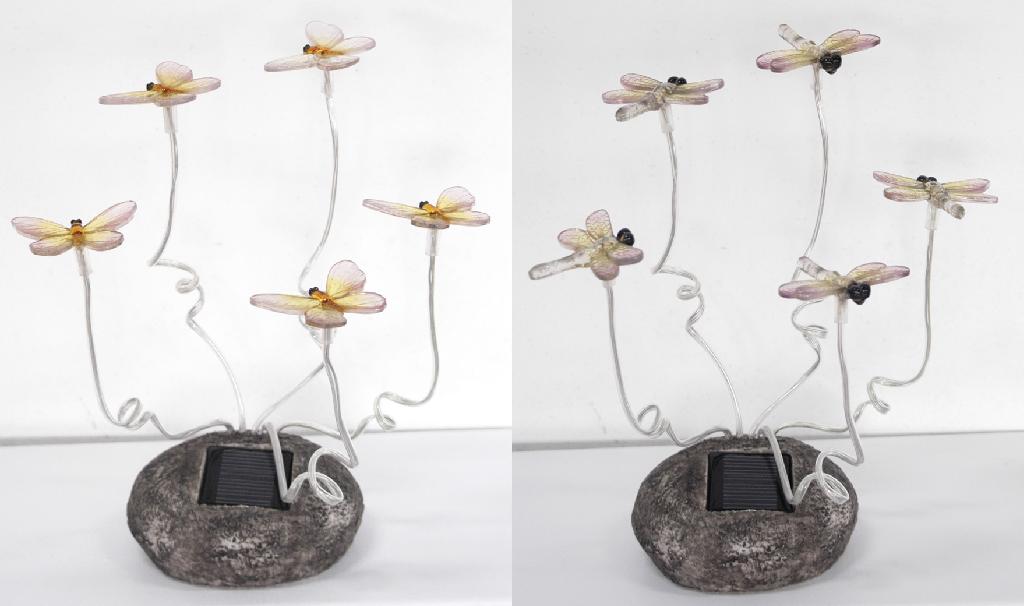 SOLAR POWERED GARDEN LIGHT. OF  PLASTIC. CONTAINING LED LIGHTS. THE LIGHTS HAVE A POLYRESIN BASE AND PLASTIC MOTIFS ON TOP IN THE SHAPE OF BUTTERFLYS OR DRAGONFLYS. DESIGNED TO COLLECT SOLAR ENERGY THROUGHOUT THE DAY AND DISCHARGE LIGHT AT NIGHT