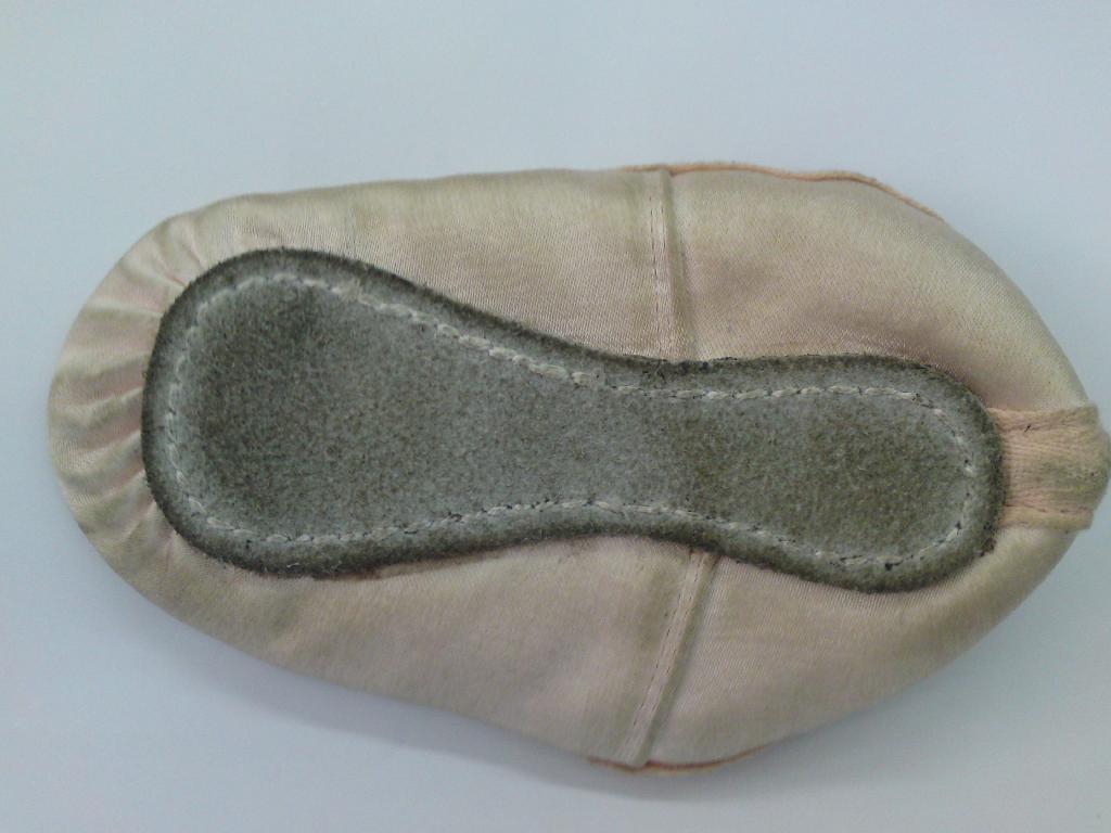 GIRLS BALLET SHOE NOT COVERING THE ANKLE. UPPERS OF PINK SATIN WITH OUTER SOLE OF LEATHER. DECORATED WITH A LITTLE TIED BOW. IN SOLE LESS THAN 24CMS.