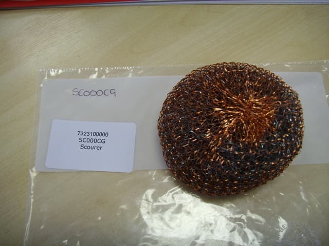 A PAN SCOURING PAD OF GALVANISED STEEL WOOL AND COPPER IN 50/50 EQUAL QUANTITY.