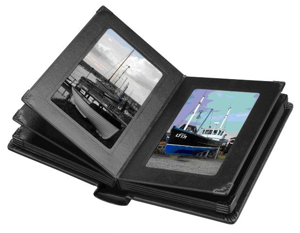 PHOTO ALBUM. OF CARDBOARD WITH LEATHER EFFECT OUTER SURFACE. WITH PAPERBOARD PAGES. WITH BLACK PAPERBOARD MOUNTS FOR THE PHOTOS TO BE INSERTED BENEATH.  FINISHED WITH A BLACK METAL CORNER. COMES PACKAGED IN A BLACK GIFT BOX.